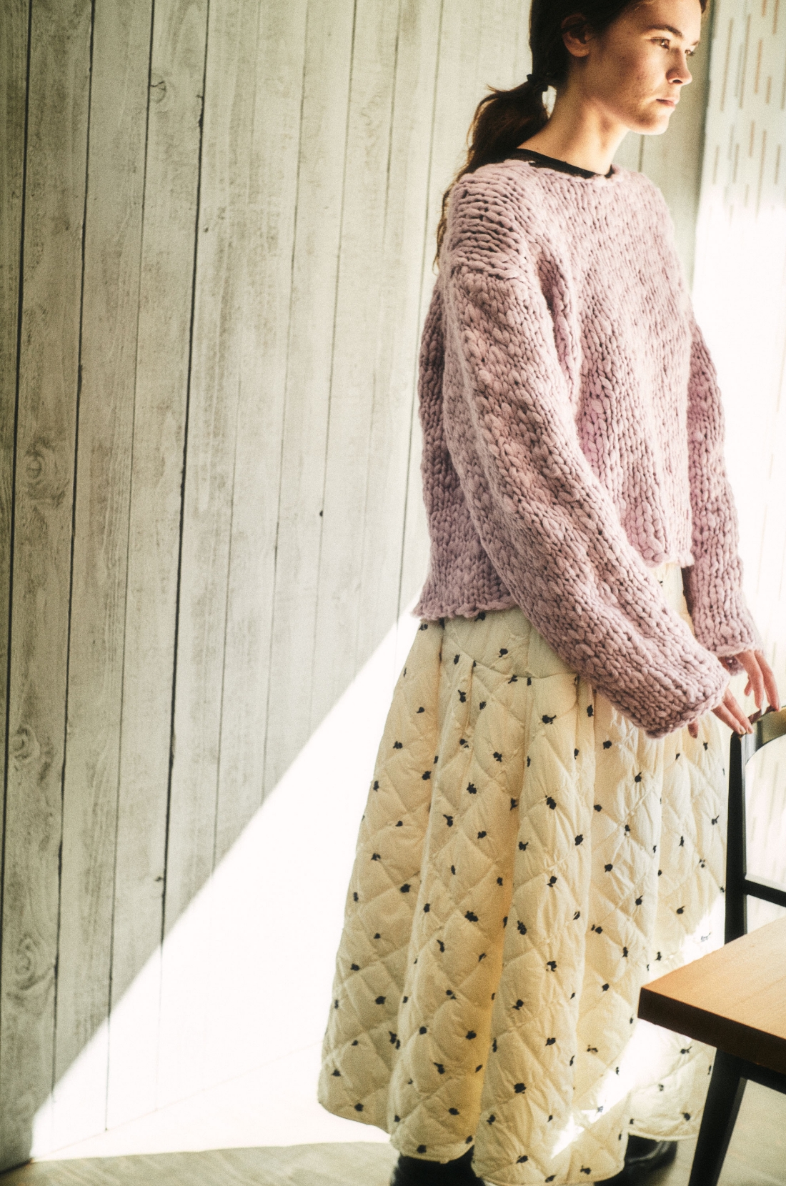 ウール混ハンドニットプルオーバー・シアーカットソー×キャミSET・エンブロイダリーキルティングスカート・インヒールジョッキーロングブーツを着用した女性