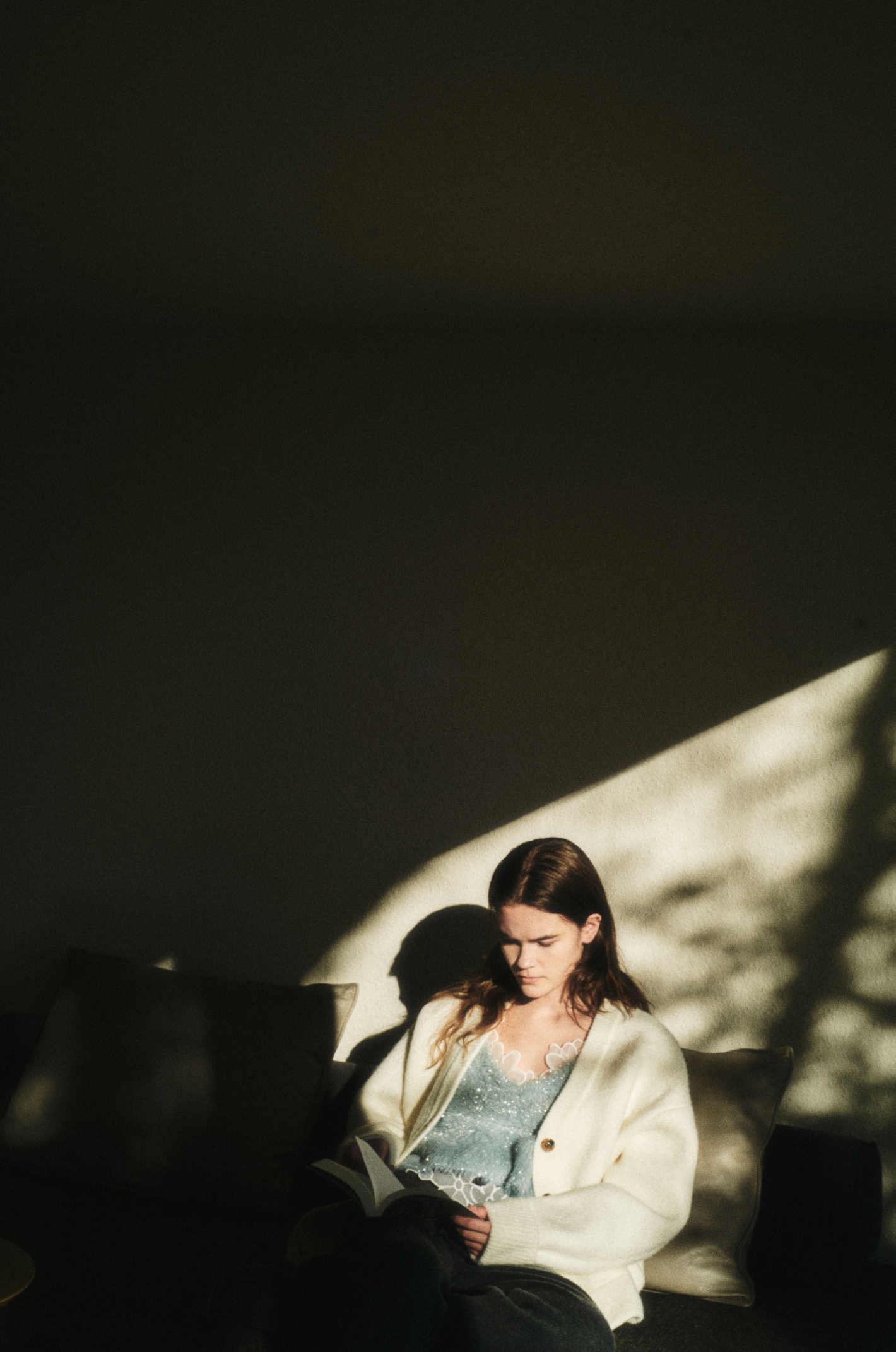 Vネックニットカーディガン・フェザーラメニットビスチェ・フラワーオーガンジービスチェ・ラムウールニットパンツ・ecoニットモードスニーカーを着用した女性