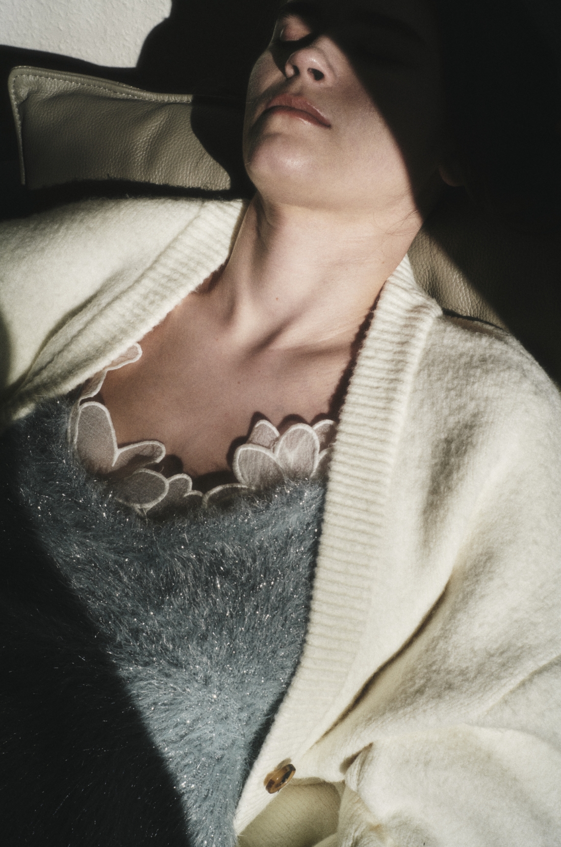 Vネックニットカーディガン・フェザーラメニットビスチェ・フラワーオーガンジービスチェ・ラムウールニットパンツ・ecoニットモードスニーカーを着用した女性