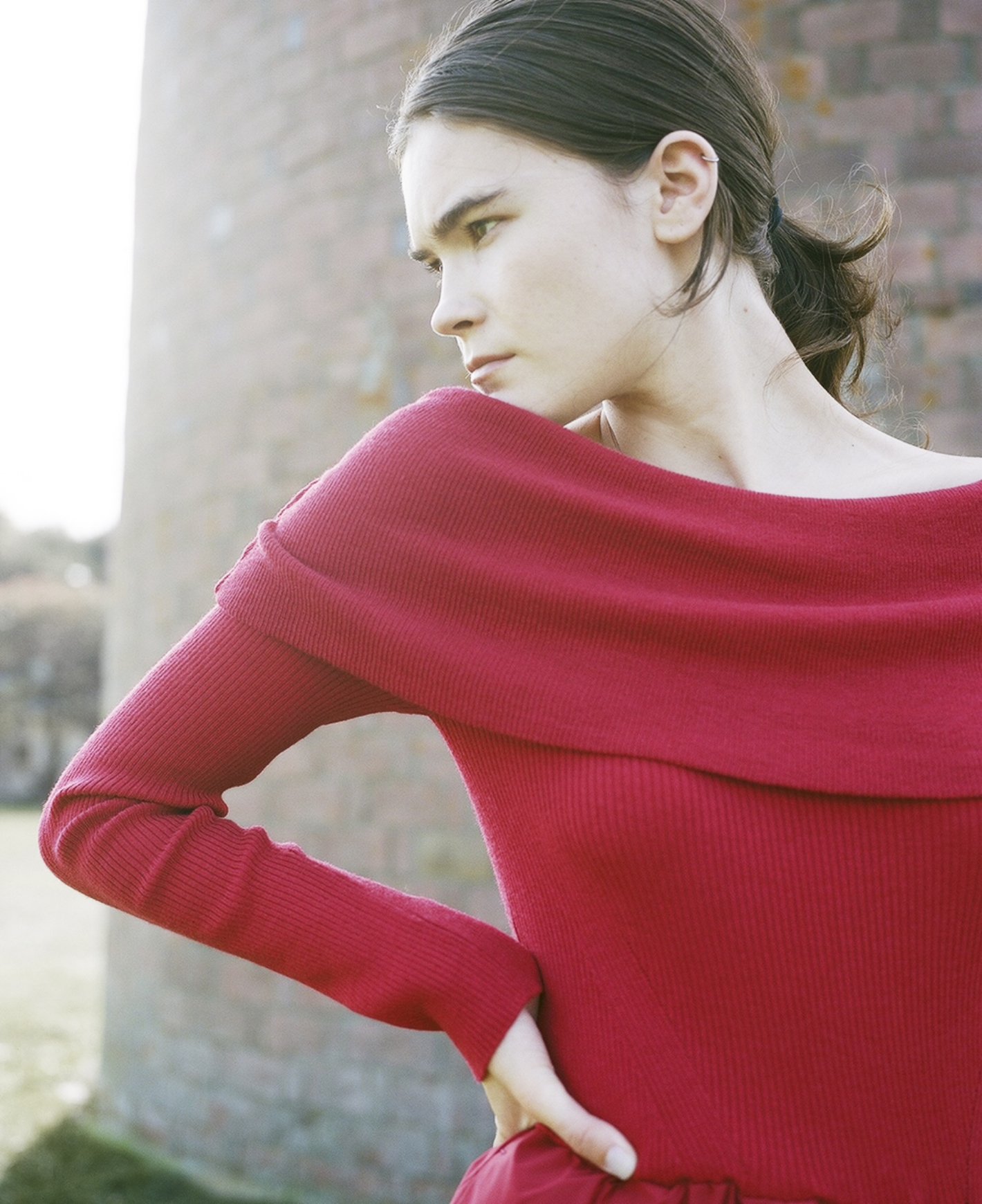 オフショルニットドッキングワンピース・コットンリブハイソックスを着用した女性