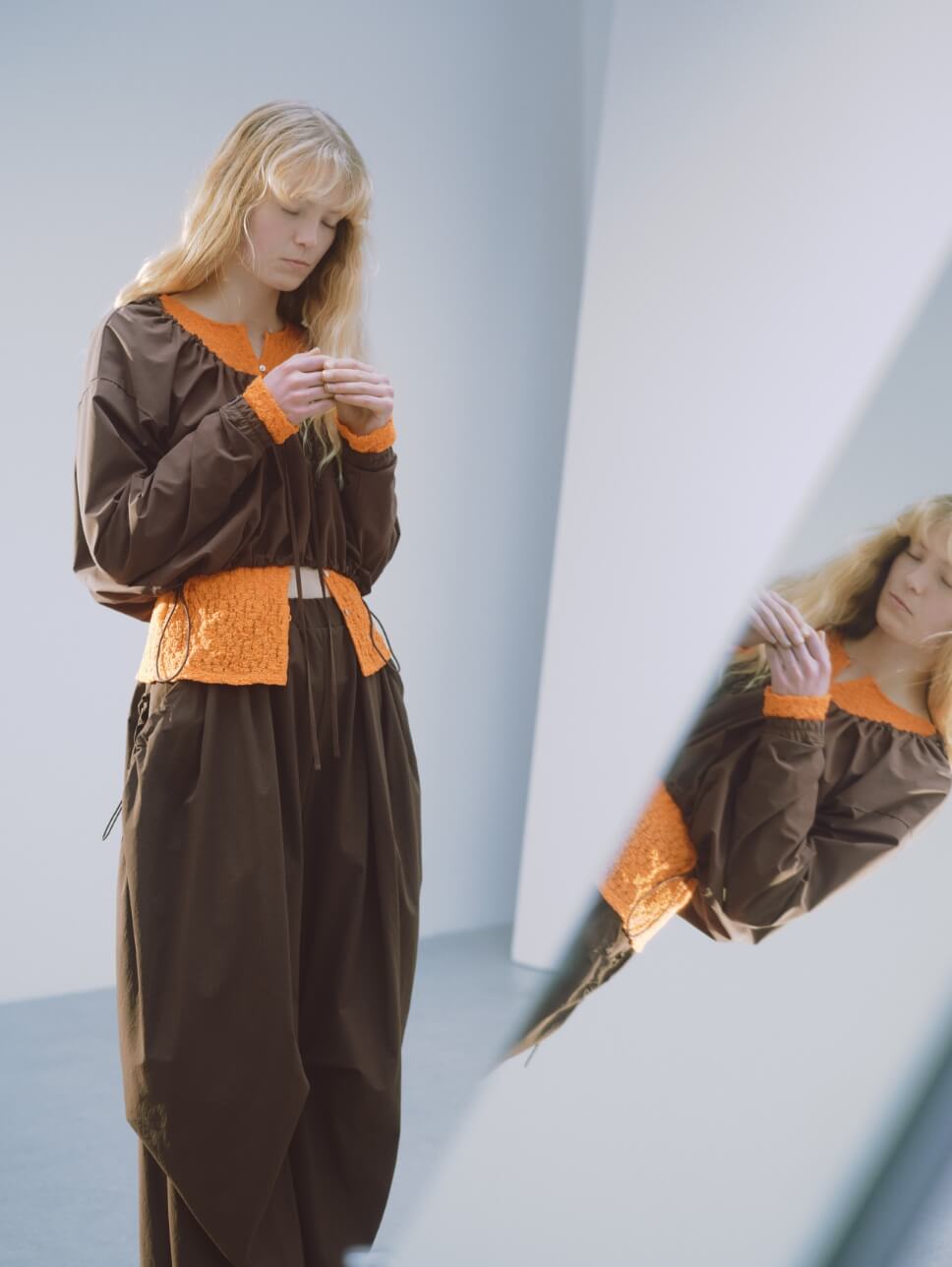 ギャザーショートフーディー、2wayストレッチレースカットソー、eco ボリュームパラシュートパンツ、ボリュームソールサンダルを着用した女性モデル