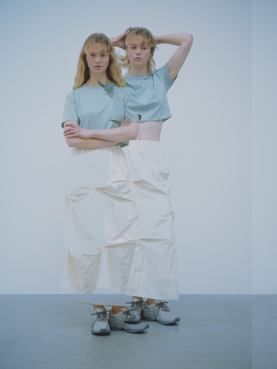 emmiロゴクロップドTシャツ、タックフォルムスカート、ワンショルダーボディーバッグ、【em】ボリュームメッシュスニーカーを着用した女性モデル