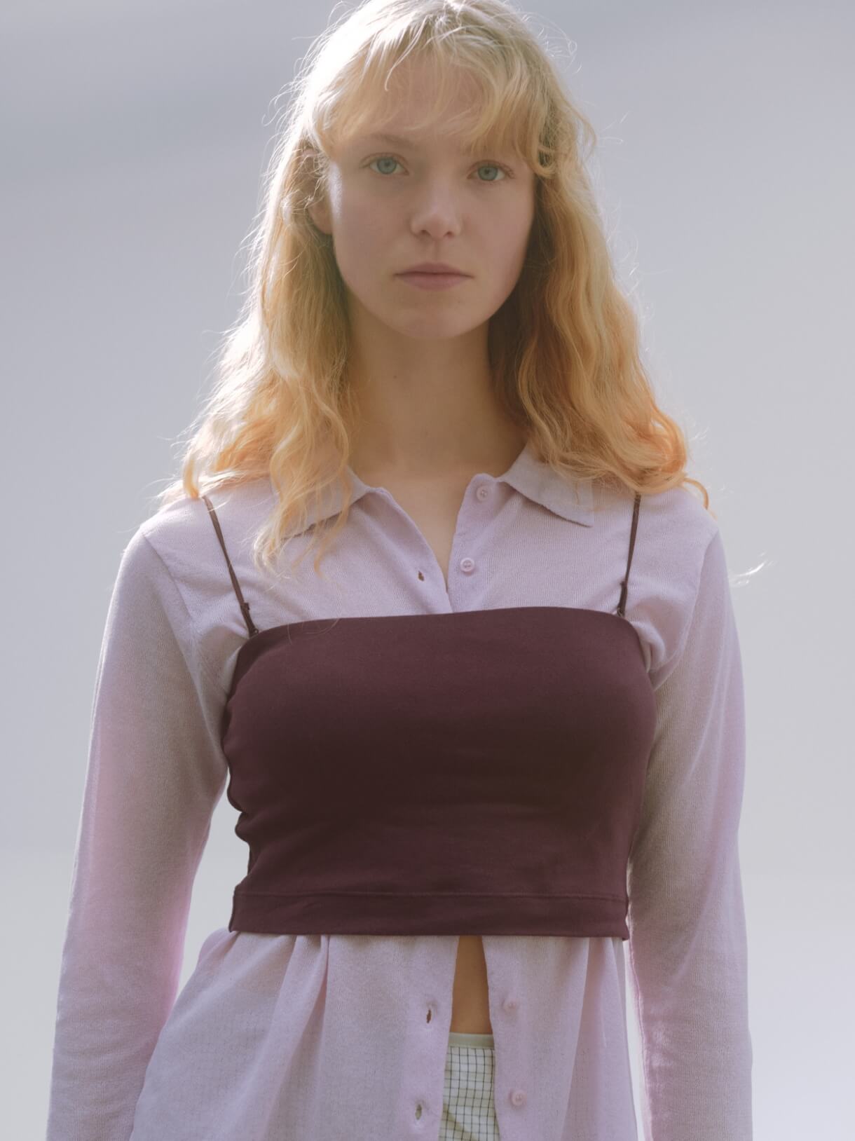 シアーニットシャツ、ベアトップブラ、サイドタックナロースカート/撥水【セットアップ対応】、【em】ソフトランニングスニーカーを着用した女性モデル