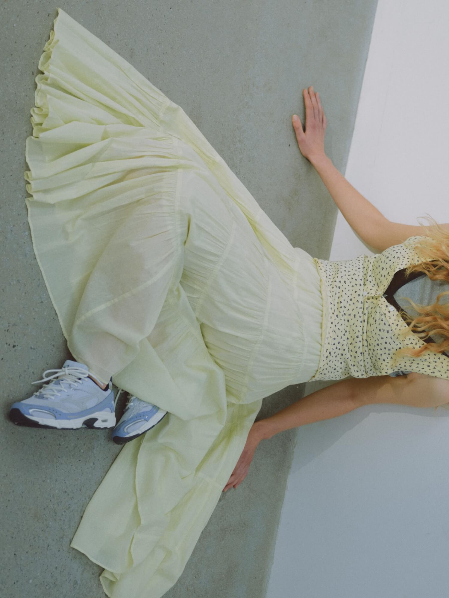 レイヤードタンクトップ、ブラトップ、コットンボリュームティアードスカート、MXR emmi (emmi×PUMA)のシューズを着用した女性モデル