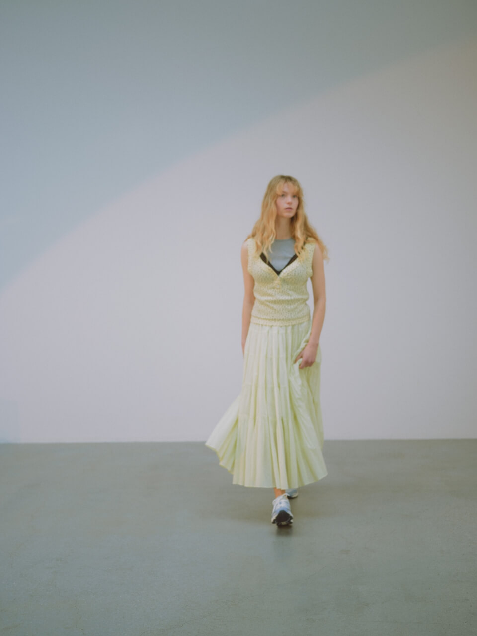 レイヤードタンクトップ、ブラトップ、コットンボリュームティアードスカート、MXR emmi (emmi×PUMA)のシューズを着用した女性モデル