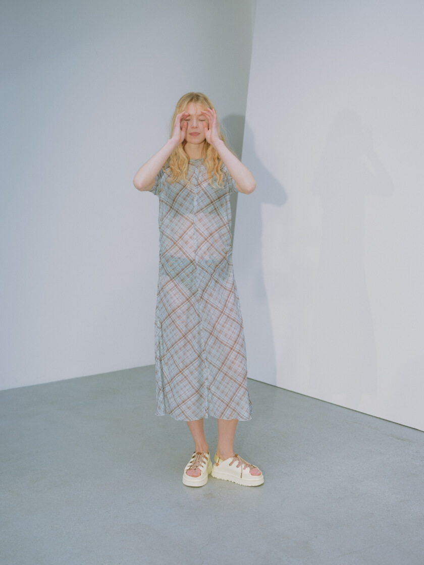 シアーメッシュチェックワンピース、リラックスヘルシーブラ、フルヒップショーツ、W GOLDENGLOW TOGGLEShoes (UGG for emmiのシューズ)を着用した女性モデル