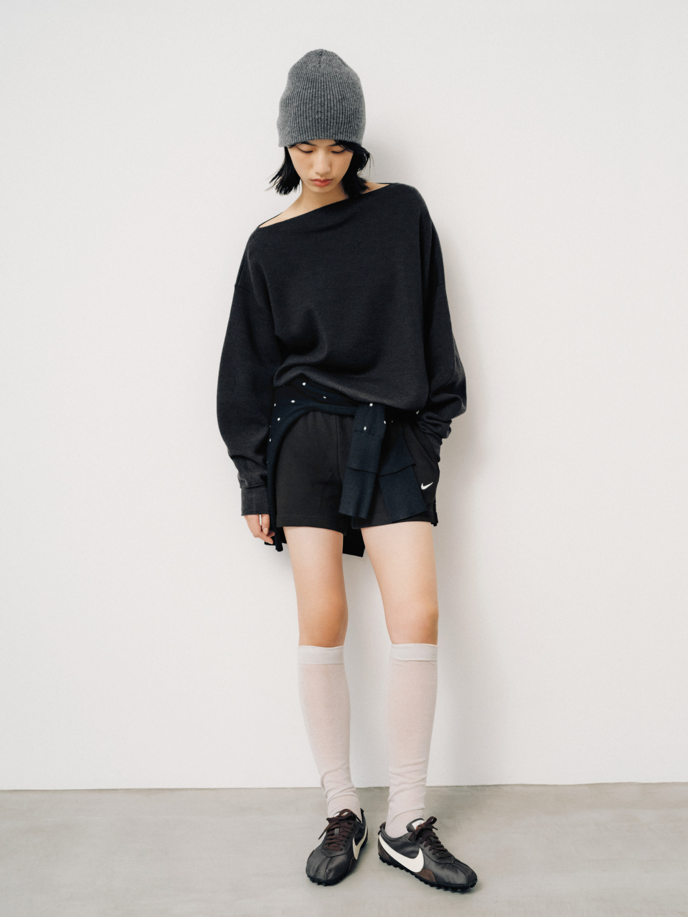 黒のニットとショートパンツ、ニット帽の全身スタイリング