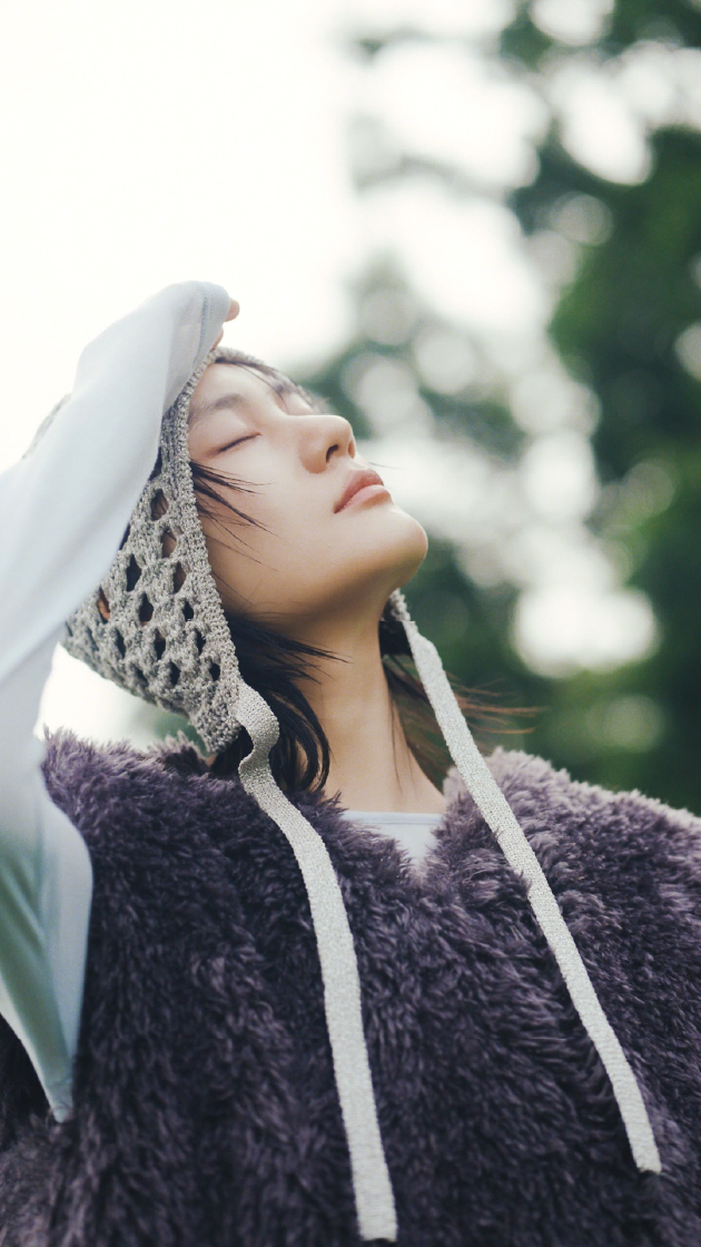 コンパクトファーベスト・オーガニックコットン強撚天竺トップス・タックドロストフォルムカーゴパンツ・ラメニットバラクラバを着用した女性