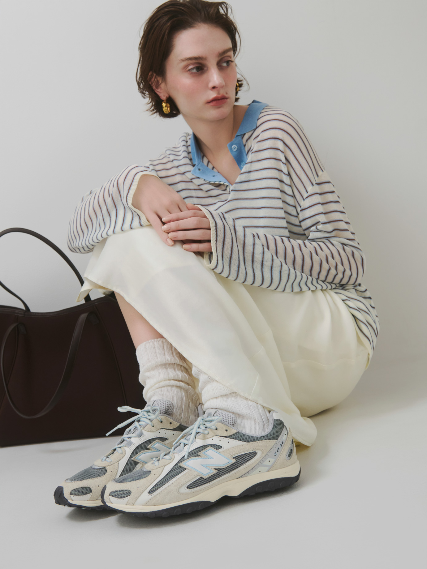 オフホワイトのシアーボーダーポロニットとサテンナロースカート【セットアップ対応】・アイボリーのレギュラーソックス・黒のネオプレーンビッグトートバッグ・グレーのU204Lを合わせたコーディネート